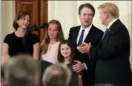  ?? EVAN VUCCI — THE ASSOCIATED PRESS FILE ?? President Donald Trump greets Judge Brett Kavanaugh his Supreme Court nominee, in the East Room of the White House in Washington. Watching is wife Ashley, with daughters Margaret, second from left, and Eliza.