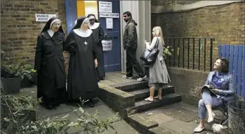  ?? Matt Dunham/Associated Press ?? Benedictin­e nuns from Tyburn Convent leave after voting in Britain’s general election Thursday at a polling station in St John's Parish Hall, London.