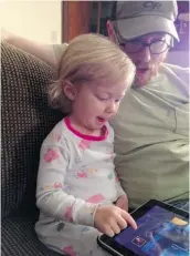  ?? BRANDI KOSKIE/ THE ASSOCIATED PRESS ?? Shelton Koskie sits with daughter Paisley, who at age 3, loves to play with an iPad.