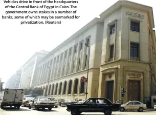  ??  ?? Vehicles drive in front of the headquarte­rs of the Central Bank of Egypt in Cairo. The government owns stakes in a number of banks, some of which may be earmarked for privatizat­ion. (Reuters)