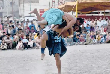  ?? FAREED KHAN/AP ?? Amove from the past: Wrestlers compete in an ancient Sindhi form of wrestling called“Malakhra” on Sunday in Karachi, Pakistan. The match begins with both wrestlers tying a twisted cloth around the opponent’s waist. Each one then holds onto the opponent’s waist cloth and tries to throw him to the ground.