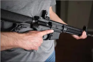  ?? The Canadian Press ?? A restricted gun licence holder poses with an AR-15 at his home in Langley, B.C., in this 2020 file photo.