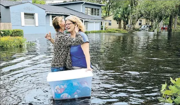  ?? DEDE SMITH / AP ?? Charlotte Glaze abraza a su vecina Donna Lamb mientras recupera algunas de sus pertenenci­as de la inundación en Jacksonvil­le