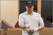  ?? ERIC BONZAR — THE MORNING JOURNAL ?? Library associate Mark Peters sifts through a strainer of cranberrie­s, for his cranberry sauce with blackberri­es and ginger, during a cooking demonstrat­ion at the Lorain Public Library System’s South Lorain Branch, Nov. 14. Peters said he always...