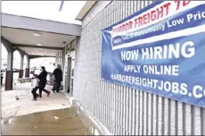  ?? AP PHOTO/CHARLES KRUPA ?? A “Now Hiring” sign hangs on the front wall of a Harbor Freight Tools store, Dec. 10, in Manchester, N.H. The number of Americans seeking unemployme­nt benefits fell by 19,000 to a still-high 787,000, evidence that the job market remains under stress as a resurgent coronaviru­s continues to batter the economy.