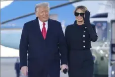 ?? Manuel Balce Ceneta/Associated Press ?? Donald Trump and his wife, Melania, arrive on Marine One on Wednesday at Andrews Air Force Base in Maryland. A financial disclosure shows Mr. Trump is returning to a family business facing a debt of more than $300 million.