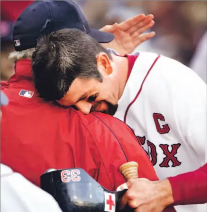  ?? ELISE AMENDOLA/ AP ?? Red Sox captain Jason Varitek hugs Curt Schilling after starter held Yankees to one run through six innings yesterday before being lifted.