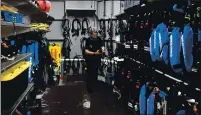  ?? DOUG DURAN — BAY AREA NEWS GROUP ?? Alice Bourget, of Watsonvill­e, a volunteer at the Monterey Bay Aquarium, gets diving equipment in the Aquarium’s locker before cleaning one of the exhibit tanks at the aquarium in Monterey. Bourget is one of many divers who volunteer to clean the exhibit tanks at the aquarium.