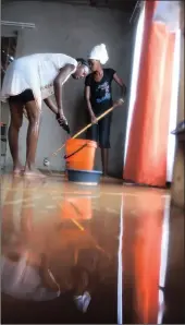  ??  ?? Amanda Ndlovu and Karneta Marule mop up after heavy rains flooded their home in Tshabalala township yesterday morning.