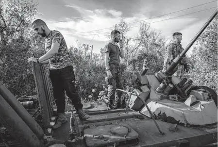  ?? Ivor Prickett/New York Times ?? Ukrainian soldiers check for salvageabl­e parts on destroyed and abandoned Russian military vehicles Saturday near a checkpoint in the recently reclaimed city of Izium, Ukraine. Russian forces withdrew from the strategic eastern city of Lyman.