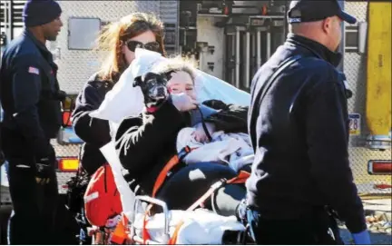  ?? TOM KELLY III — FOR DIGITAL FIRST MEDIA ?? A young woman and her dog are seen being taken to a Goodwill Ambulance after they were rescued from the third floor of a burning building at the intersecti­on of North York Street and Second Street in Pottstown Thursday afternoon. The woman was checked...