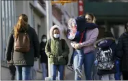  ?? SETH WENIG/ASSOCIATED PRESS ?? Children and their caregivers arrive for school in New York, Monday, March 7, 2022. COVID cases are starting to rise again in the United States, with numbers up in most states and up steeply in several. One expert says he expects more of a “bump” than the monstrous surge of the first omicron wave, but another says it’s unclear how high the curve will rise and it may be more like a hill.