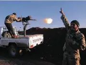  ?? Getty Images ?? Turkish-backed fighters from the Free Syrian Army fire toward Kurdish People’s Protection Units positions in the area of Afrin on Saturday.