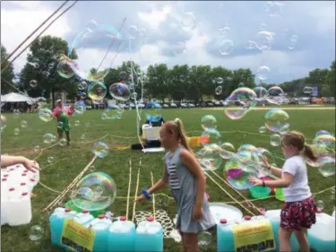  ?? EVAN BRANDT — MEDIANEWS GROUP ?? Kids in Memorial Park never seemed to tire of popping the bubbles made by Grandpop Bubbles during the GoFourth Festival Thursday.