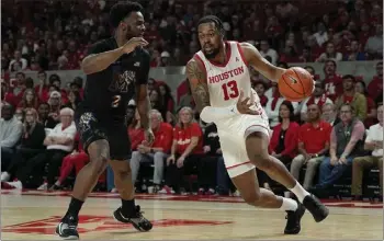  ?? KEVIN M. COX — THE ASSOCIATED PRESS ?? Houston forward J'Wan Roberts, who scored 20points, drives against Memphis guard Alex Lomax during Sunday afternoon's American Athletic Conference game, won by the second-ranked Cougars 72-64.