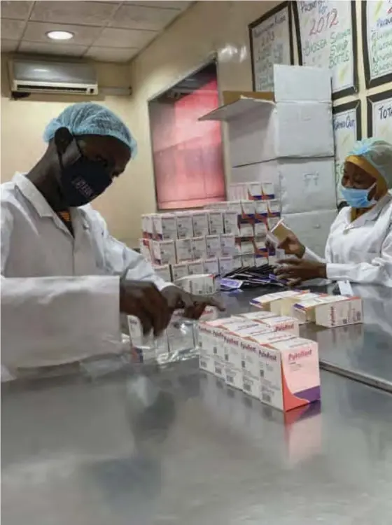  ?? ?? Workers at Biofem Industries processing facility stick authentica­tion labels on drugs in Lagos