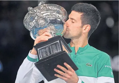  ??  ?? KING’S KISS: Novak Djokovic of Serbia with the trophy after winning his ninth Australian Open singles title.