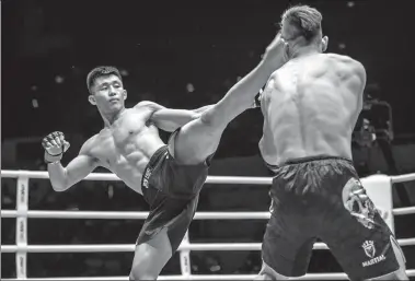  ?? PROVIDED TO CHINA DAILY ?? Mixed martial artist Zhao Zhikang lands a roundhouse kick during a catch weight bout against compatriot Ma Xudong at One Championsh­ip’s Guangzhou event at Tianhe Gymnasium on Saturday. Zhao defeated Ma via guillotine choke in round three.