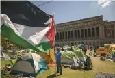  ?? YUKI IWAMURA/AP ?? A protester holds a Palestinia­n flag Friday at the Columbia University encampment in New York.