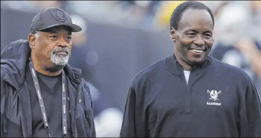  ?? D. Ross Cameron The Associated Press ?? Former Raiders cornerback Lester Hayes, right, and safety George Atkinson walk the sideline before a 2018 game against the Pittsburgh Steelers at Oakland-Alameda County Coliseum. With the aid of Stickum, Hayes had 13 intercepti­ons in 1980.