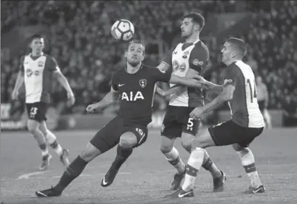  ?? PHOTS BY FRANK AUGSTEIN, THE ASSOCIATED PRESS ?? Tottenham’s Harry Kane vies for the ball with Southampto­n’s Jack Stephens and Oriol Romeu, right, in a 1-1 Premier League soccer draw Sunday.