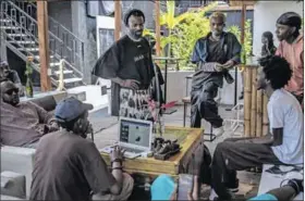  ?? ?? Close knit: Moise Turahirwa with friends and other creatives at their studio in Kigali, Rwanda.