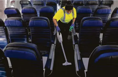  ?? Yi-Chin Lee / Staff photograph­er ?? G2 Secure Staff employee Angela Blanco vacuums a United Airlines aircraft Tuesday before it departs on its next flight from George Bush Interconti­nental Airport.