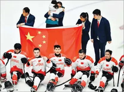  ?? WEI XIAOHAO / CHINA DAILY ?? Team China’s para ice hockey players celebrate winning bronze at the Beijing 2022 Paralympic Winter Games following a 4-0 triumph over South Korea at the National Indoor Stadium on March 12.