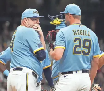  ?? KAYLA WOLF/GETTY IMAGES ?? Milwaukee Brewers pitching coach Chris Hook, left, talks with pitcher Trevor Megill during a game at American Family Field last September.