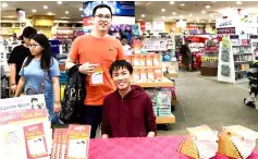  ??  ?? Malcolm (seated) with a fan during a recent book-signing event.