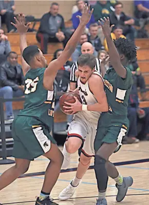  ?? RICK WOOD / MILWAUKEE JOURNAL SENTINEL ?? Martin Luther's Shaun Harrison (left) and Ace Evans close in on Racine Prairie's Logan Krekling on Friday night.