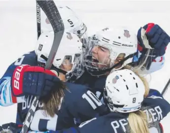  ??  ?? Team USA’s Gigi Marvin, middle, celebrates with her teammates after scoring against Finland during the first period of a semifinal-round game Monday in South Korea.