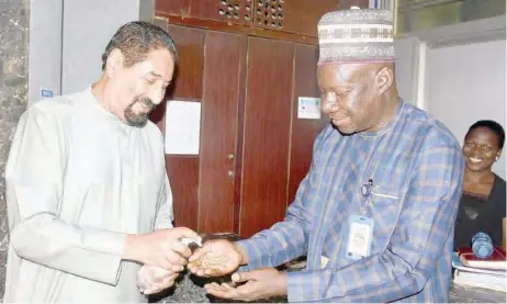  ??  ?? Yakubu Dati (r), Plateau State commission­er for land, survey and town planning, being offered sanitizer by Attia Nasreddin, chairman/chief executive officer, NASCO Group of Companies, during the visit of the commission­er to the NASCO