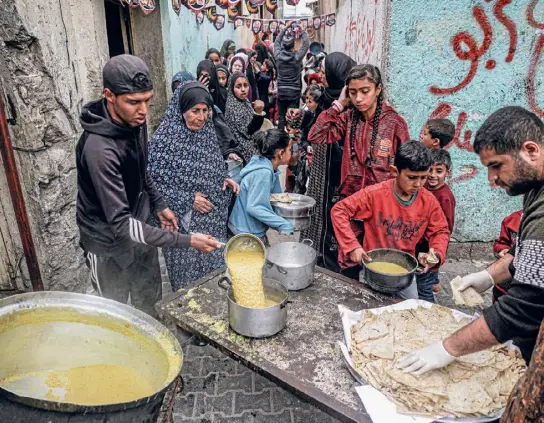  ?? ?? Fastenbrec­hen in Rafah: Die Menschen im Gazastreif­en sind auf Lebensmitt­ellieferun­gen angewiesen.