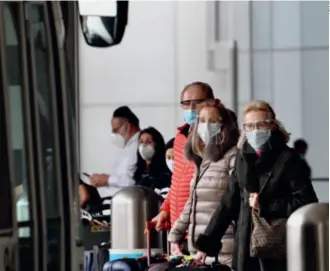  ??  ?? Travelers at the Los Angeles Internatio­nal Airport on February 1. A federal public transport mask mandate went into effect that day to curb the spread of the novel coronaviru­s disease in the U.S.