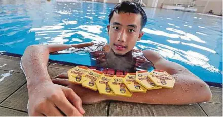  ?? PIC BY MUHAMMAD HATIM AB MANAN ?? Low Zheng Yong with his seven gold medals at the Malaysian Schools Sports Council Swimming Championsh­ips in Malacca.