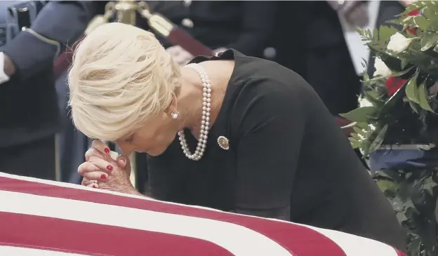  ?? PICTURE: GETTY IMAGES ?? Cindy Mccain, John Mccain’s wife, kneels at her husband’s coffin during ceremonies honouring the late US senator