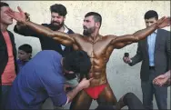  ?? WAKIL KOHSAR / AFP ?? Hares Mohammadi, 25, is covered in fake tan during a bodybuildi­ng and fitness contest in Kabul, Afghanista­n, on April 18.