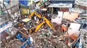  ??  ?? Rescue operation under way after a single-storey house collapsed on another structure in Mumbai’s Malwani area