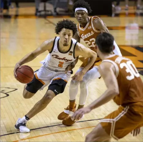  ?? Associated Press ?? Cade Cunningham, above, driving past Texas’s Kai Jones (22) and Brock Cunningham (30) is the presumptiv­e No. 1 pick.