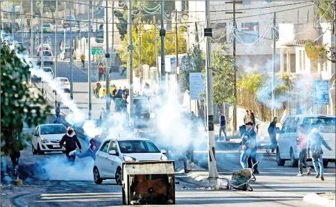  ?? — AFP photo ?? Palestinia­n protestors clash with Israeli forces near an Israeli checkpoint in the West Bank town of Bethlehem, following the US president’s decision to recognise the city of Jerusalem as the capital of Israel.