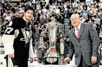  ?? BRUCE BENNETT Getty Images/tns ?? The Penguins’ Sidney Crosby (87) stands next to the Prince of Wales Trophy after being presented by Bill Daly, right, Deputy Commission­er of the NHL after the Penguins eliminated the Flyers in the Eastern Conference Finals in 2008 in Pittsburgh.