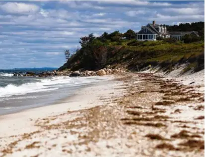  ?? CARLIN STIEHL FOR THE BOSTON GLOBE ?? A house stands atop a hill at the end of Menemsha Public Beach in Chilmark. This Martha’s Vineyard town saw the highest median home price appreciati­on between 2020 and 2022.