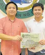  ?? ?? Uy receives a certificat­e of appreciati­on from Noveleta Mayor Dino Reyes-Chua for planting 10,000 mangrove trees.