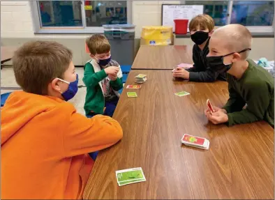  ?? PHOTO PROVIDED ?? Kids wear masks while playing a card game during a program offered by the Saratoga Regional YMCA.