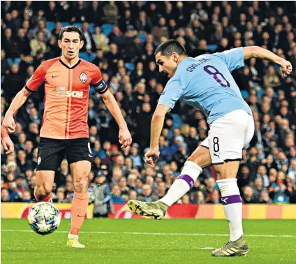  ??  ?? Clinical finish: Ilkay Gundogan calmly sidefoots home to put City 1-0 ahead against Shakhtar Donetsk