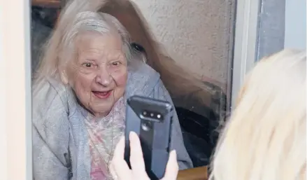  ?? JEFFREYT. BARNES/AP ?? Laura Corridi shows a photo to her mother, Emma Sahl, 93, on March 6 at Northgate Health Care Facility in North Tonawanda, NewYork.