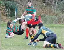  ??  ?? Finlay Carmichael is unceremoni­ously upended by two Helensburg­h defenders.