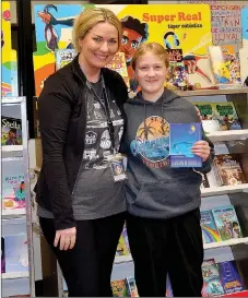  ?? Annette Beard/Pea Ridge TIMES ?? Klassy Whitlow, sixth-grade student, spent her own money to bless fellow students during the book fair at Pea Ridge Middle School. Librarian Charity Fingerhut (left) gave Klassy a book — “Out of my heart” by Sharon Draper. For more photograph­s, go to the PRT gallery at https://tnebc. nwaonline.com/photos/.