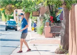  ?? EDDIE MOORE/JOURNAL ?? Richard Norris of Palm Springs, California, checks out the galleries along Santa Fe’s renowned Canyon Road on Thursday. At least for now, visitors from California are still subject to a 14-day travel quarantine under a revised order issued by Gov. Michelle Lujan Grisham.